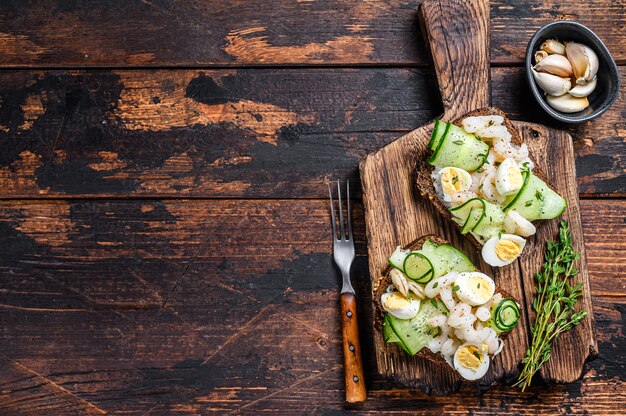 Sándwiches de camarones, gambas, huevos de codorniz y pepino sobre pan de centeno