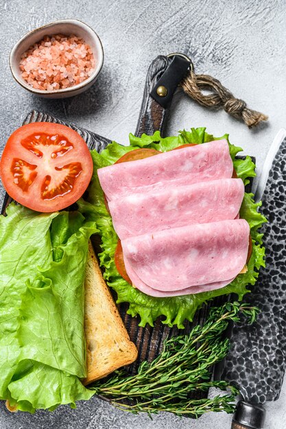 Sándwiches de club tradicionales con jamón de pavo, queso, tomate y lechuga.