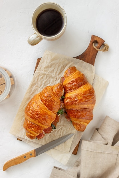 Sándwiches de croissants con prosciutto, albahaca y queso blanco. Cocina francés. Desayuno.