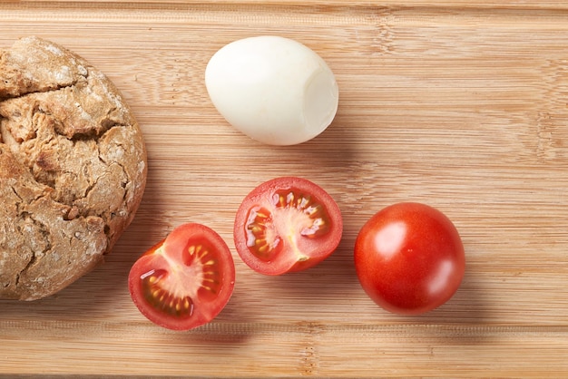 Sándwiches con huevos de tomate y mayonesa en un plato de madera