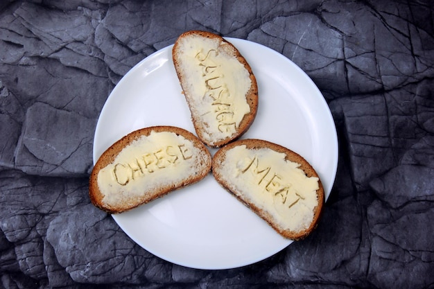 Sándwiches con la inscripción carne, salchichas, queso en mantequilla. Simboliza la crisis alimentaria.