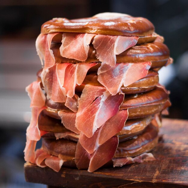 Foto sándwiches con jamón colocados en una tabla de cortar de madera para entender un concepto y tradición de alimentación