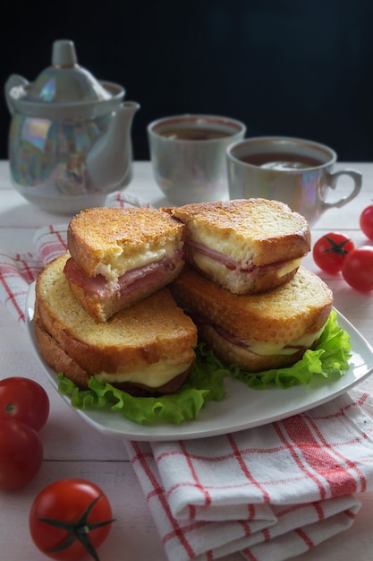 Foto sándwiches con jamón, lechuga y tomate.