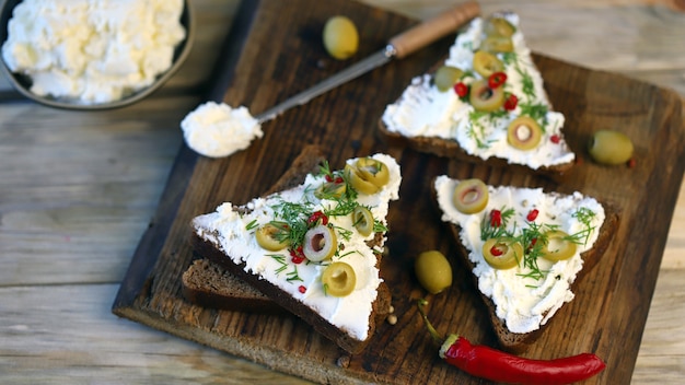 Sándwiches de mascarpone con aceitunas y especias.