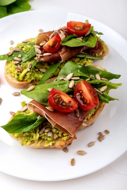 Sandwiches mit Avocadocreme, Tomaten und Jamon.