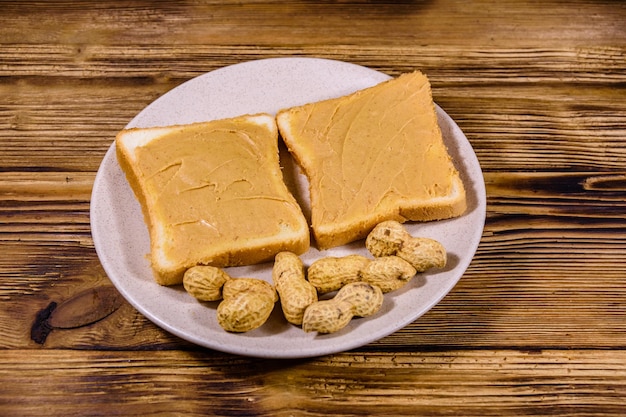 Sandwiches mit Erdnussbutter in Platte auf Draufsicht des Holztischs