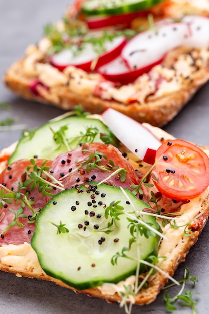 Foto sandwiches mit frischkäse, gemüse und salami.