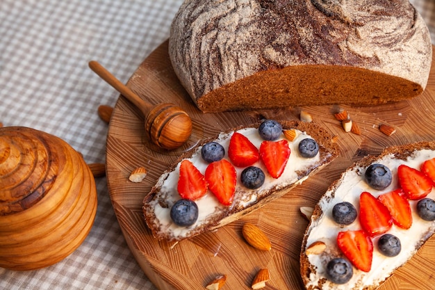 Sandwiches mit hausgemachtem Roggenbrot, Honig, Käse und Beeren