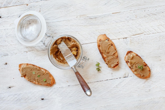 Sandwiches mit hausgemachter Leberpaste und einem Topf mit Paste auf einem Tisch