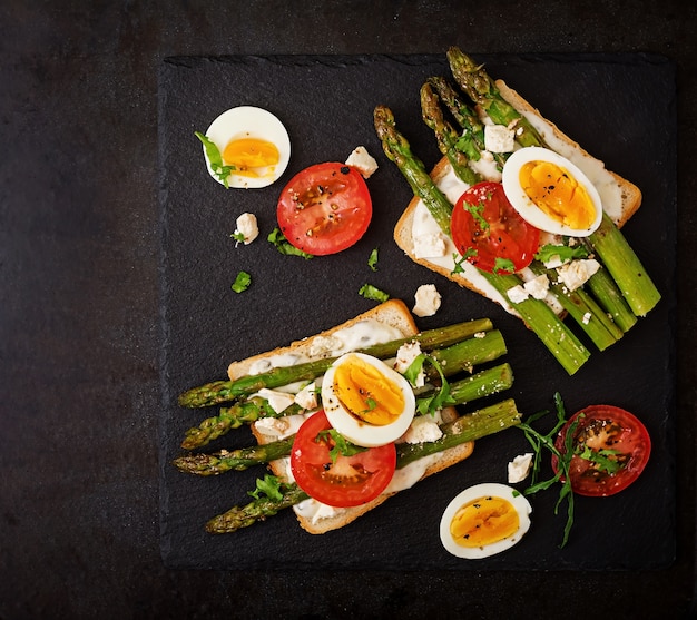 Sandwiches mit karamellisiertem Spargel, Feta-Käse, Tomaten und Eiern.