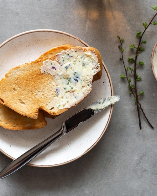 Sandwiches mit Kräuterbutter auf grauem Hintergrund Gesunde hausgemachte Kräuterbutter und Brot