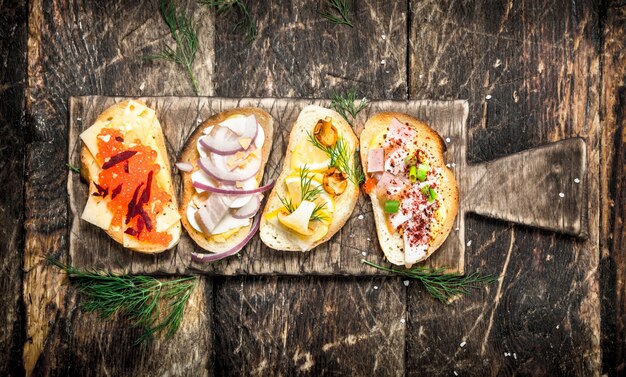 Sandwiches mit Pilzen, Salami, rotem Kaviar und frischem Gemüse auf geröstetem Brot