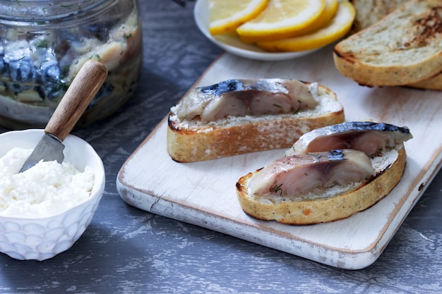 Sandwiches mit Quark und Gravlax aus Makrele, serviert mit Zitrone.