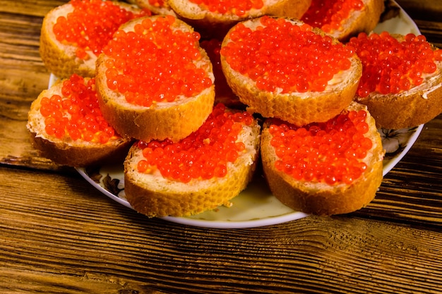 Sandwiches mit rotem Kaviar auf rustikalem Holztisch