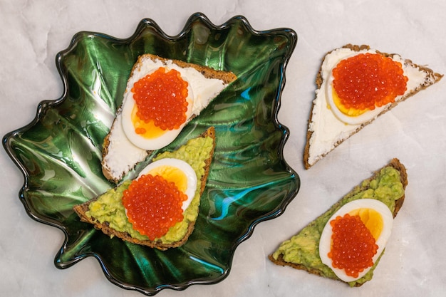 Sandwiches mit rotem Kaviar-Frischkäse, gekochten Eiern und Avocado
