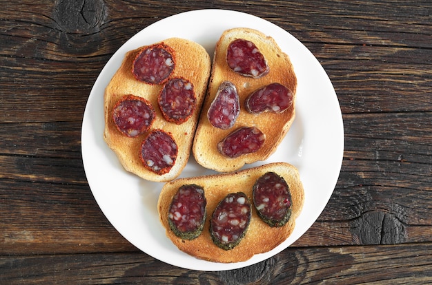 Sandwiches mit Salami auf einem Holztisch