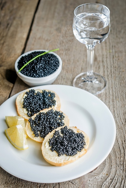 Foto sandwiches mit schwarzem kaviar und glas wodka