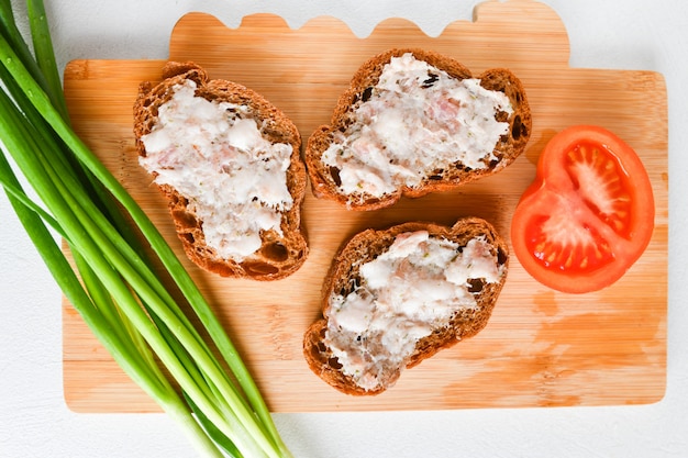 Sandwiches mit Zwiebeln und Tomaten. gebackenes Fett auf einem Brötchen verschmiert. ukrainisches Essen