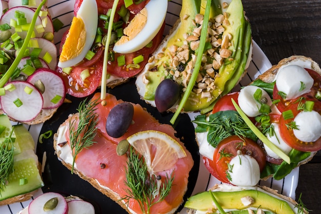 Sándwiches o tapas con pan, queso crema, vegetales y sabrosas coberturas.