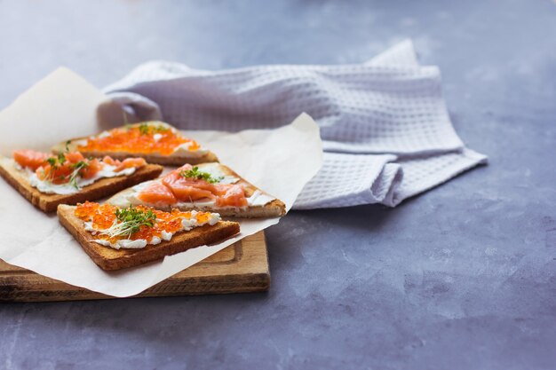 Sandwiches oder Tapas aus rotem Kaviar und rotem Fisch mit Mikrogrün, Meeresfrüchten Luxus-Delikatesse