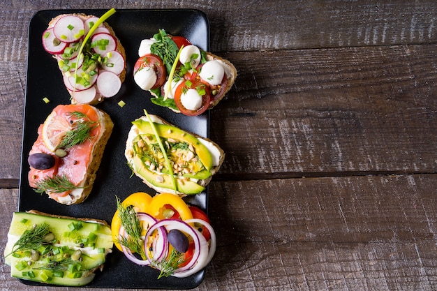 Sandwiches oder Tapas mit Frischkäse, Gemüse und Lachs