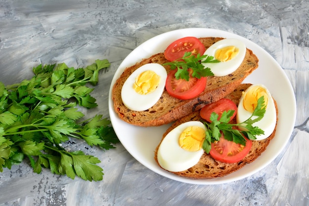 Sándwiches de pan integral con rodajas de huevos y tomates en el plato