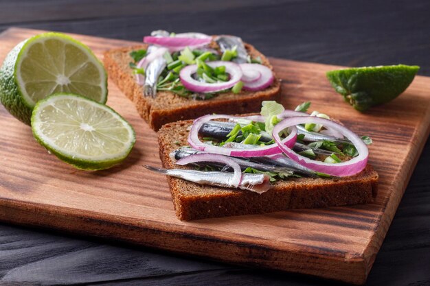 Sándwiches de pan negro con canales de espadín salado con cebolla y perejil