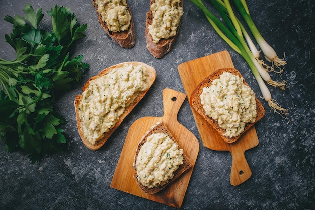 Sándwiches con paté y hierbas verdes en un oscuro