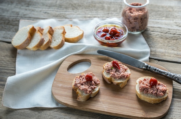 Sandwiches con paté sobre tabla de madera