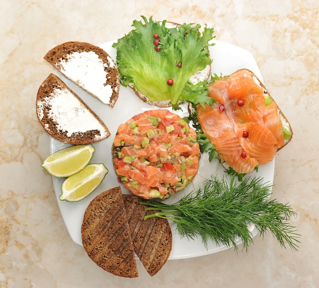 Sandwiches con pescado rojo y tartar de salmón en un plato