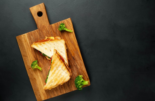 Sándwiches de queso de brócoli en tabla de cortar de madera, en concreto, fondo de pizarra