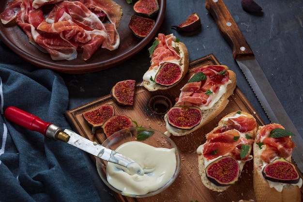 Sándwiches con queso crema y jamón, aperitivos españoles de primer plano con vino