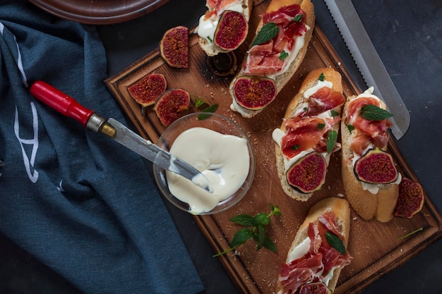 Sándwiches con queso crema y jamón, aperitivos españoles de primer plano con vino