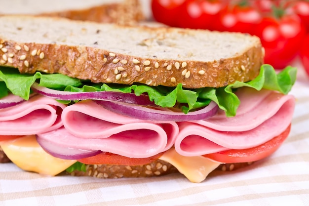 Sándwiches con queso de jamón y tomate en una tabla de madera