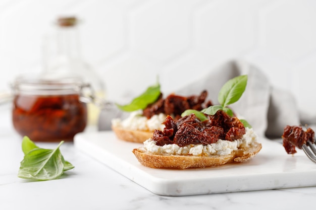 Sándwiches con tomates secos requesón queso ricotta y albahaca Bruschetta snack aperitivos