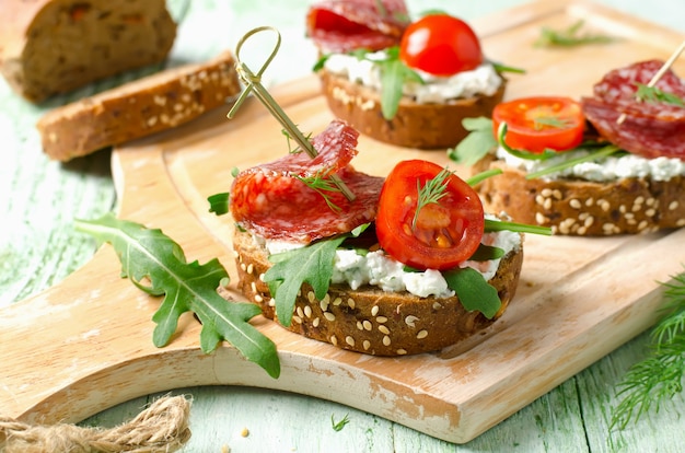 Sándwiches de tostadas frescas con salami de requesón, tomates cherry y rúcula