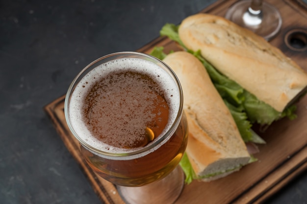 Sandwiches und Bier auf einem Holztisch