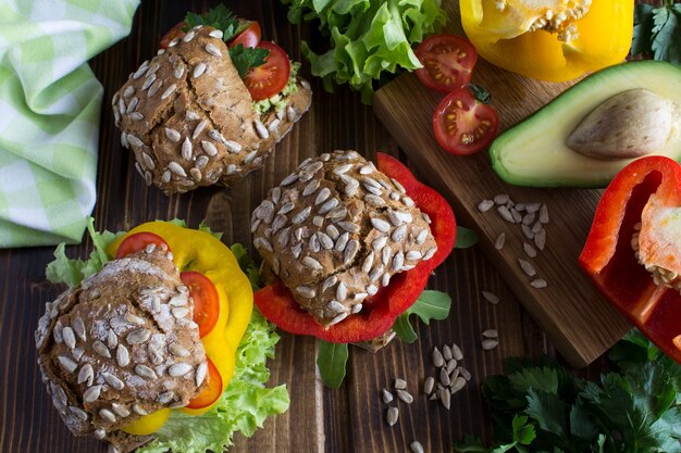 Sándwiches vegetarianos con verduras en mesa de madera. Vista superior.