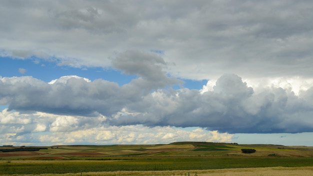 Sanfte grüne Hügel mit dramatischen Wolken im landwirtschaftlichen Herzen Spaniens in der Nähe von Salamanca