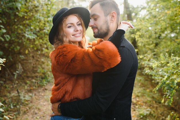 Sanfte und stilvolle Paare machen einen Spaziergang im Herbstpark