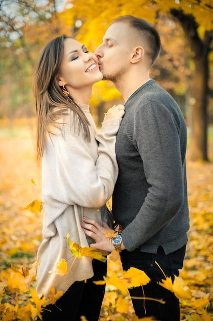 Sanfter Kuss bei einem Date eines jungen Paares im Herbstpark