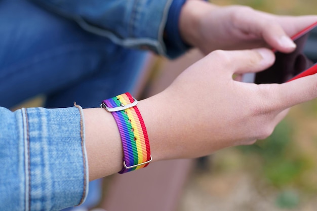 Sanftmütig mit Regenbogen-LGtb-Armband, das auf dem Handy schreibt