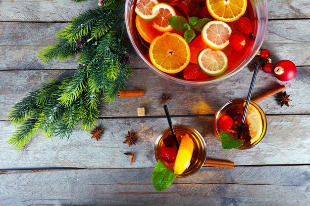 Sangria in Schüssel und Gläsern mit Weihnachtsdekoration auf Holztisch hautnah