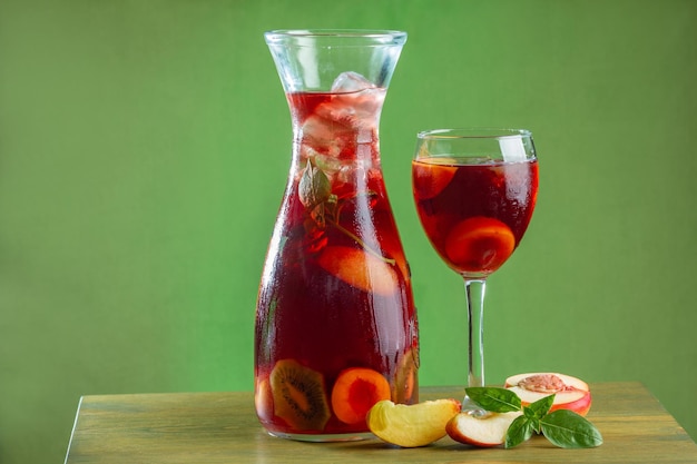 Sangria Sommererfrischungsgetränk mit weinroter Aprikosenminze und Eis in einer Karaffe