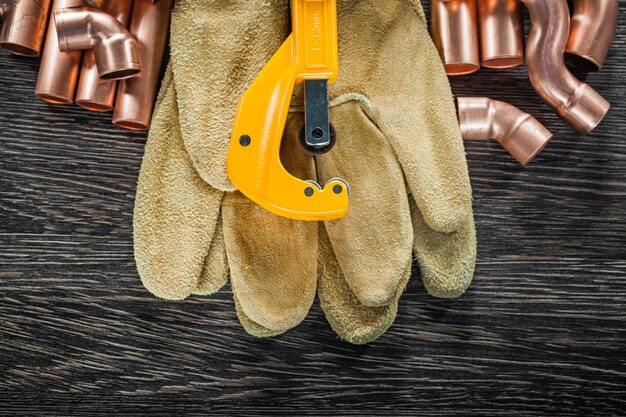 Sanitär-Kupfer-Wasserrohrschere Lederschutzhandschuhe auf Holzbrett