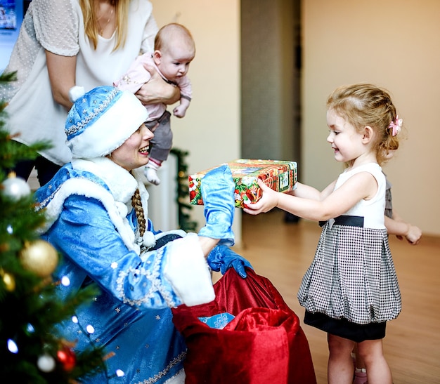 Sankt Petersburg, Russland - 24. Dezember 2016: Kinder-Neujahrsgrüße. Kinder spielen mit der Schneewittchen. Grüße, Geschenke, Tanz um einen Weihnachtsbaum. Familienporträts.