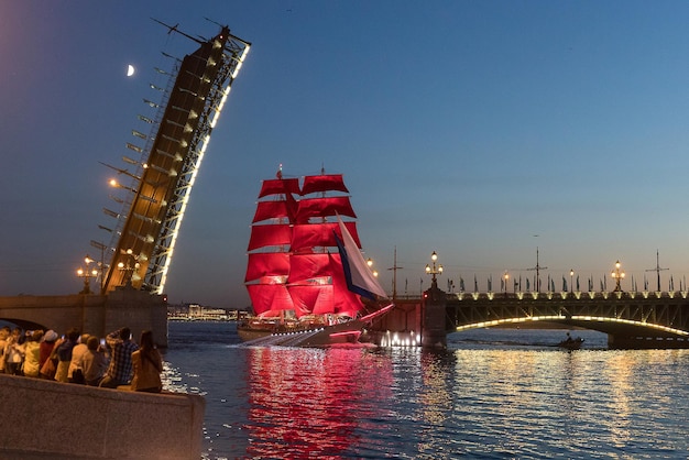 Sankt Petersburg Russland Ein Schiff mit scharlachroten Segeln fährt unter der Troizki-Brücke durch Weiße Nächte in St. Petersburg Feiertag der scharlachroten Segel Segelschiff auf den Newa-Brücken von St. Petersburg