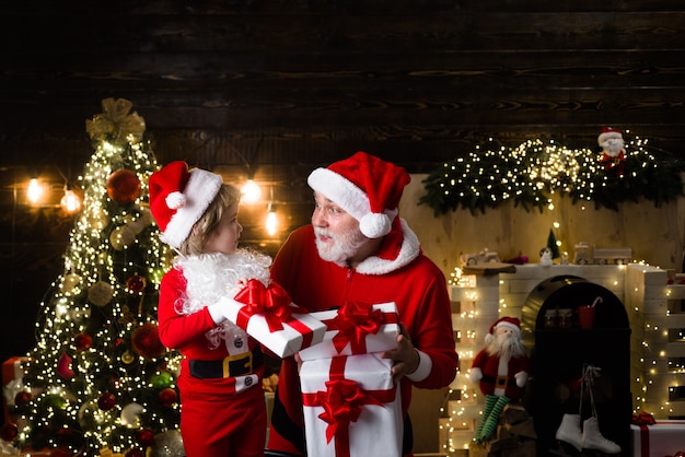 Santa con ayudante regalo de navidad vacaciones familiares niño con santa claus y regalo de navidad