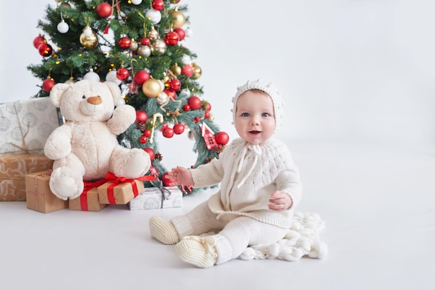 Santa Baby Weihnachtsbaum Hintergrund Frohes neues Jahr Kind im Strickanzug