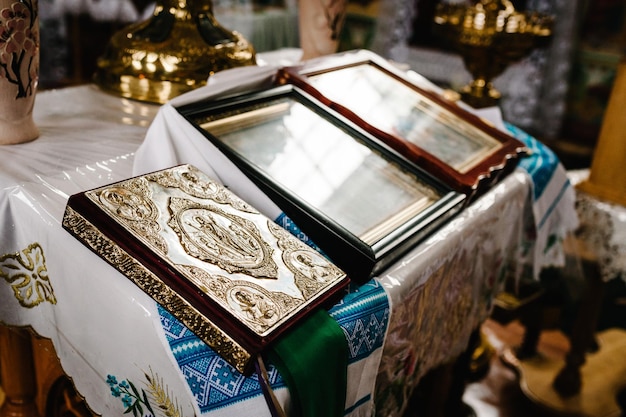 La Santa Biblia decorada con oro e íconos se encuentra sobre la mesa en la iglesia Cerrar